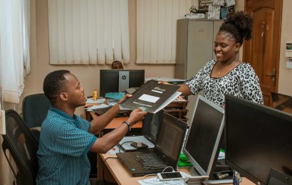 I.T Tutor Handing Over Students' Book to Her Colleague.