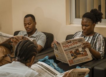 Teachers With Students Reading Newspapers in the Library